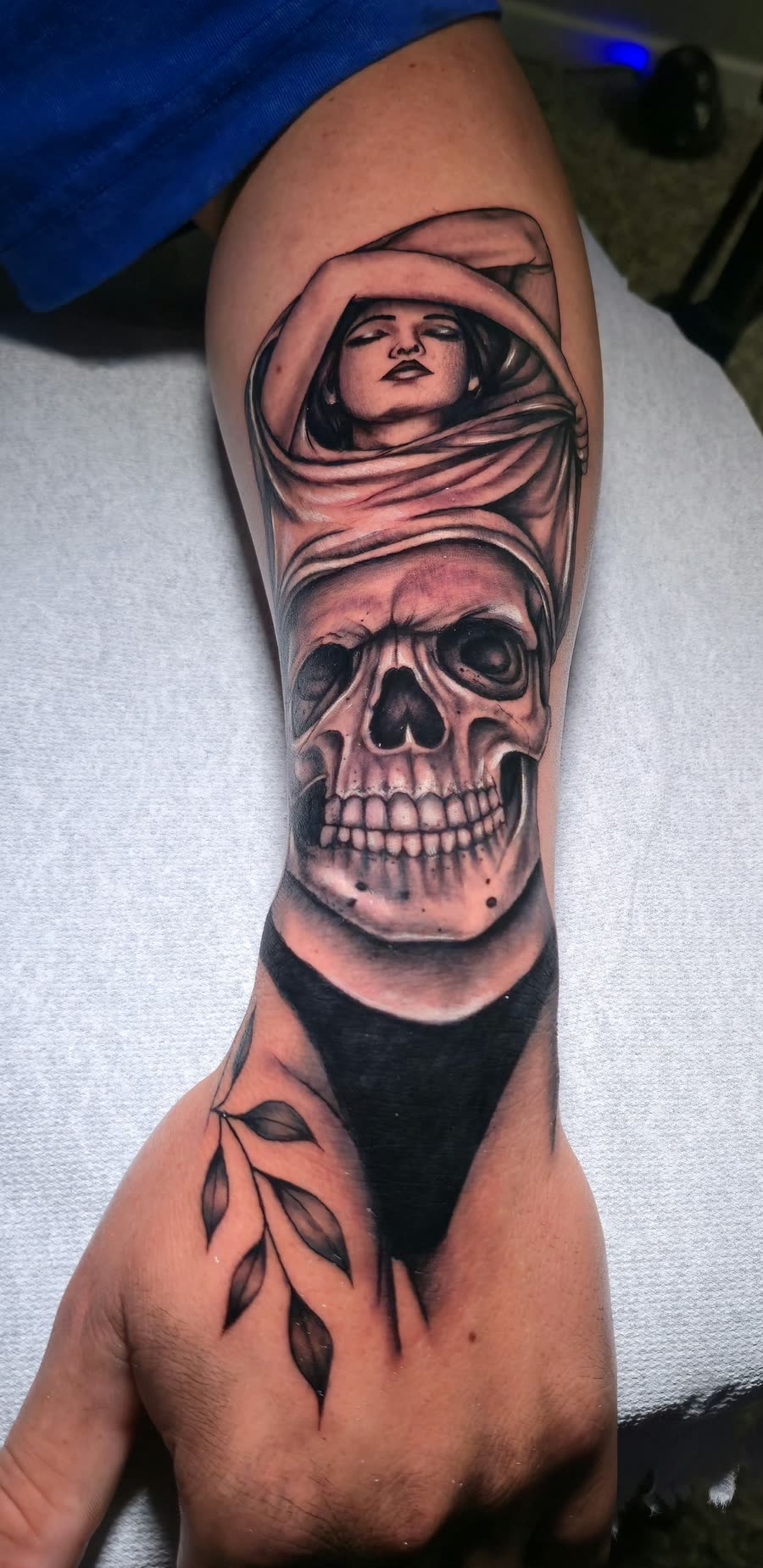 Mujer con velo y calavera en antebrazo y mano