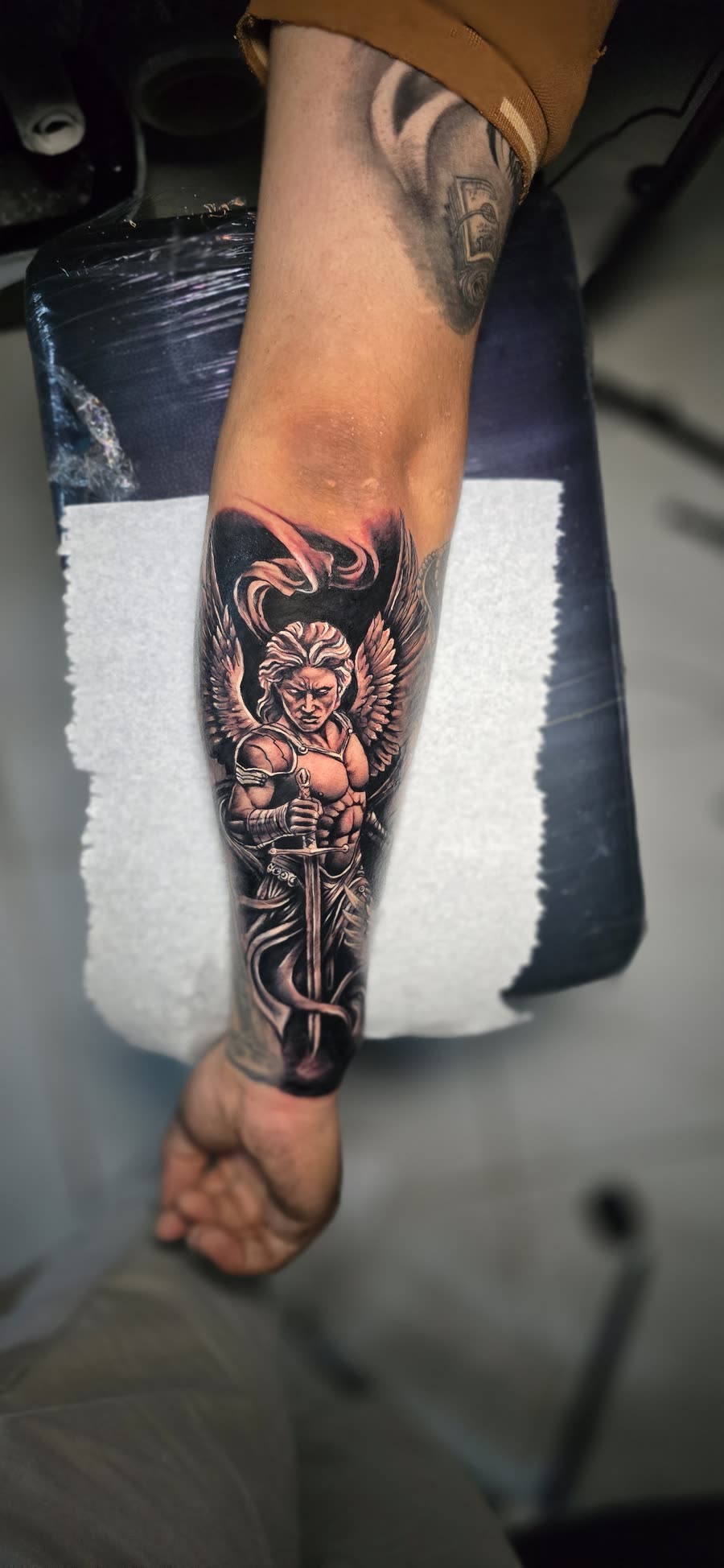 Arcángel guerrero con espada y alas en antebrazo